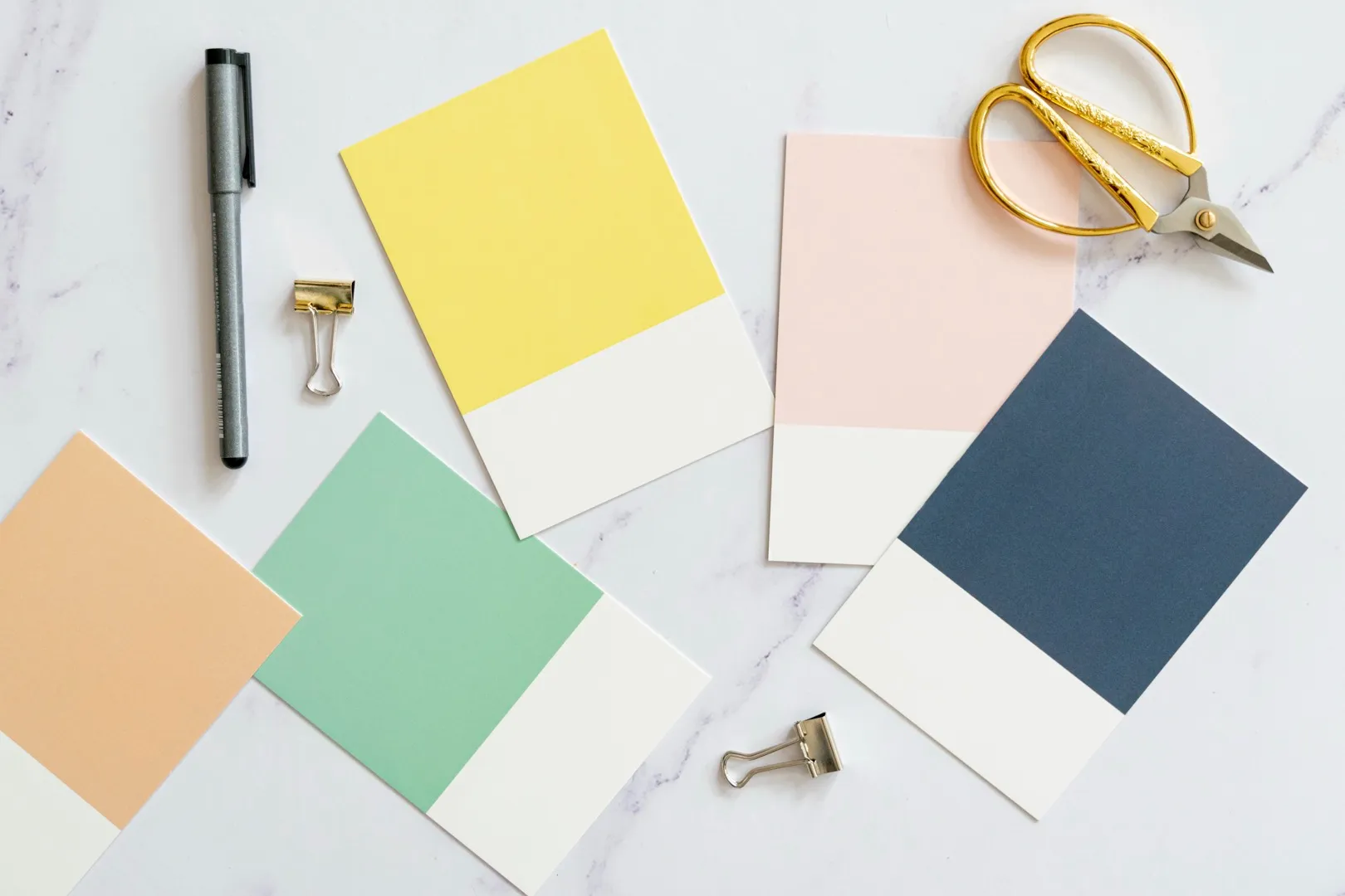 Printed colour swatch chips arranged in a flat lay on a studio desk.