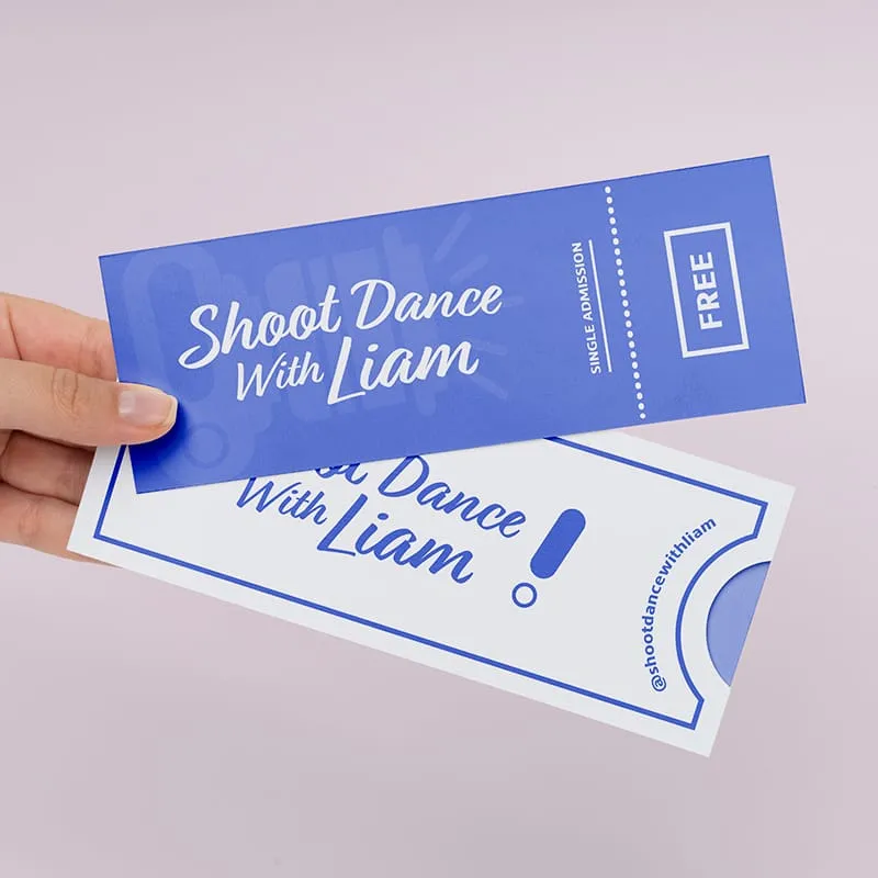 Two tickets, one blue and one white, with the text "Shoot Dance With Liam" on them. The tickets are being held by a hand. The background is a light pink color.