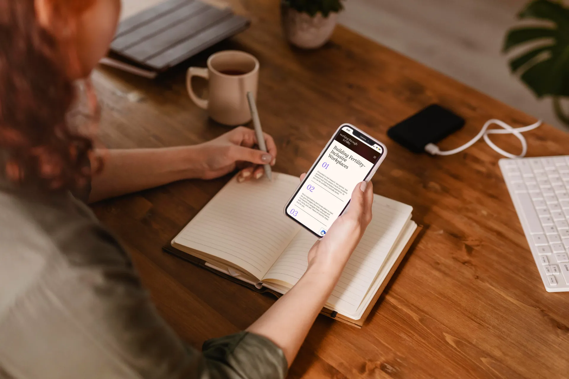 Person holding a phone showing the Working Through Fertility website. mobile web design by Berlew Design Studio.